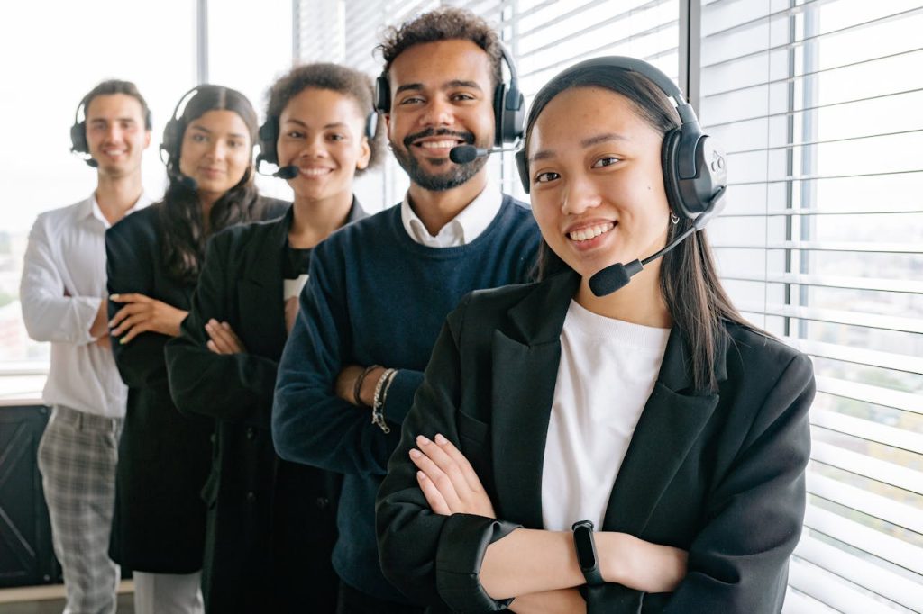 A diverse group of smiling call center agents in an office setting.